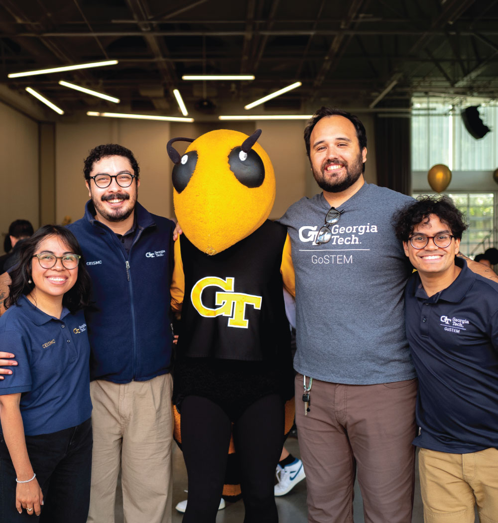 four smiling adults with GT mascot